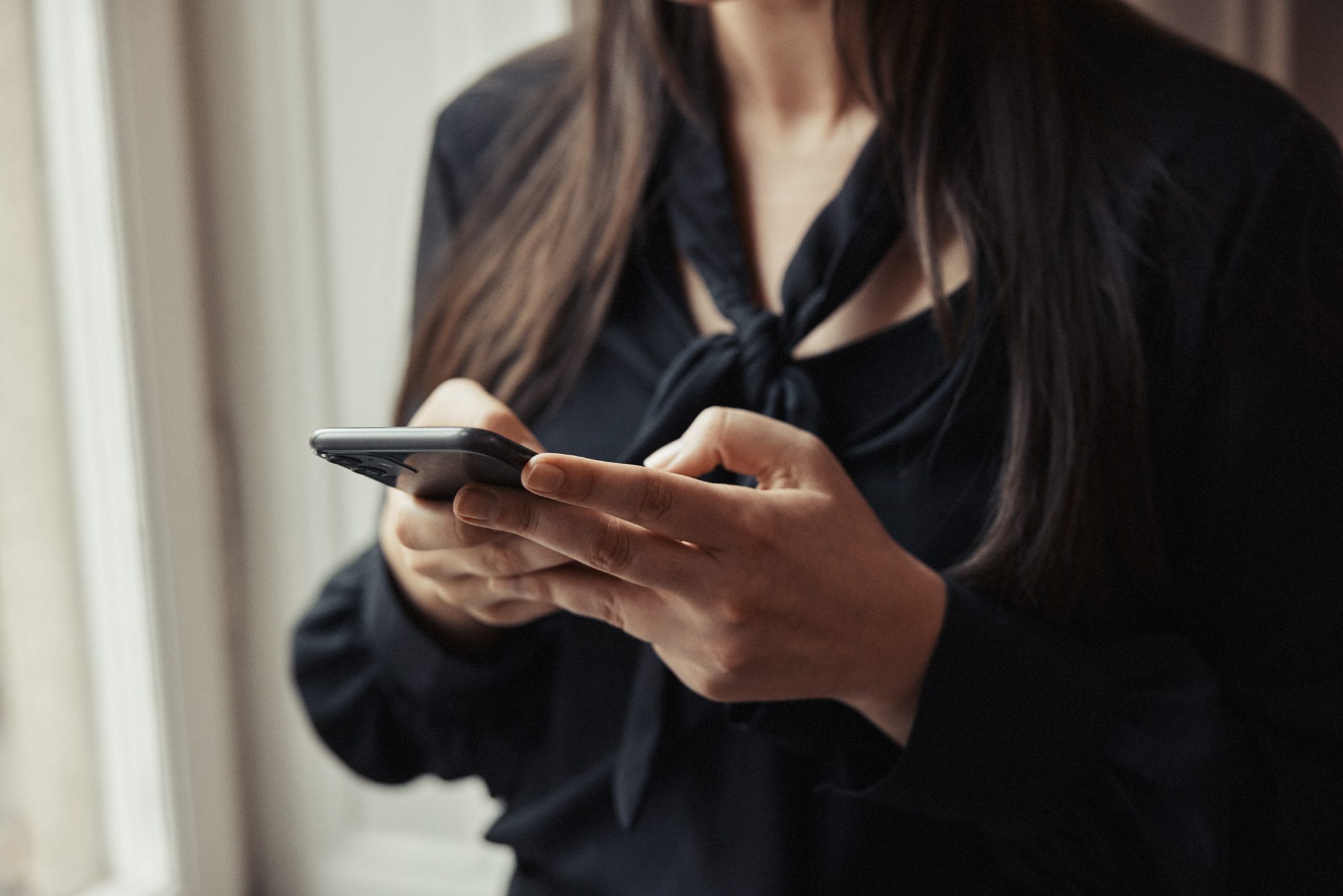 En kvinna med telefon i händerna