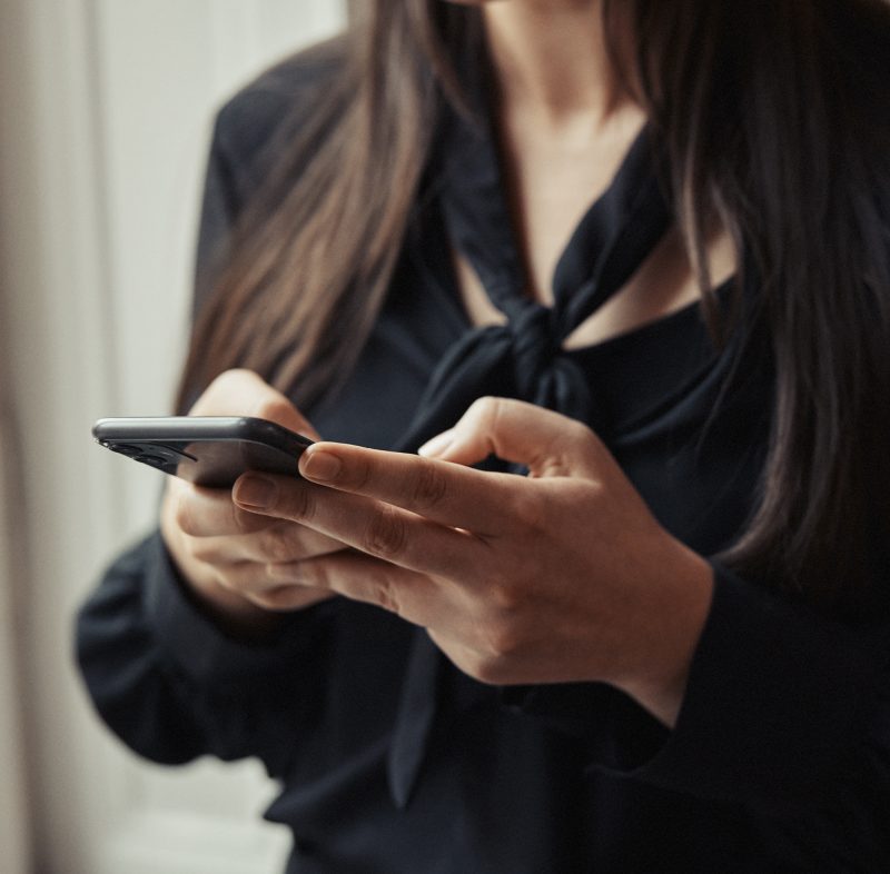 En kvinna med telefon i händerna