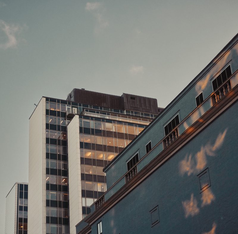 Två skyskrapor med en äldre byggnad