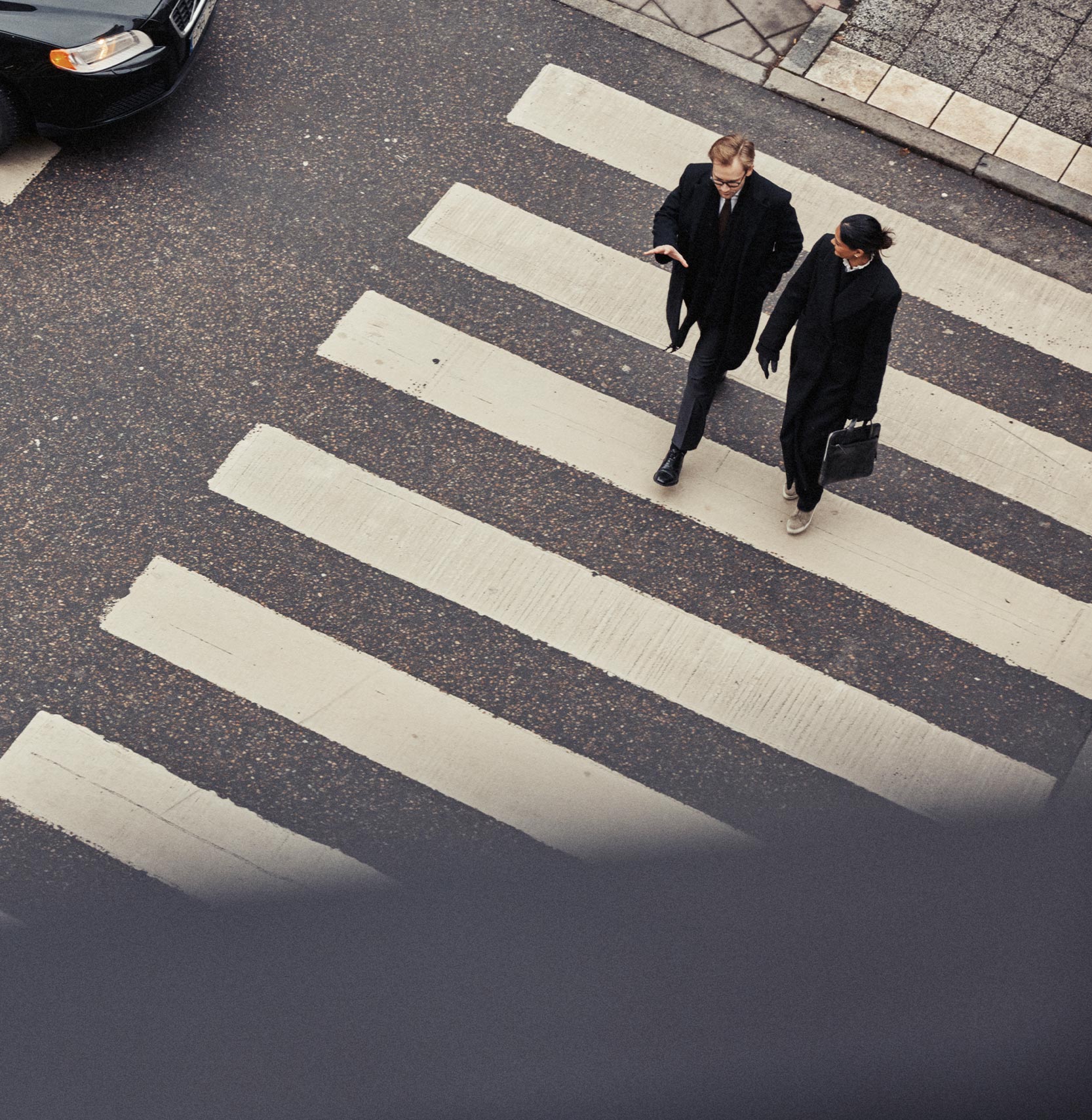 Två personer går över ett övergångsplats
